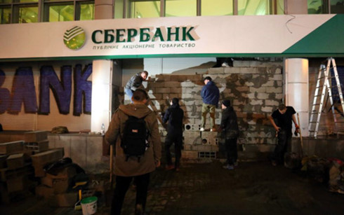 Những người quá khích xây tường chắn cửa ngân hàng Sberbank ở thủ đô Kiev, Ukraine. (Ảnh: rferl)