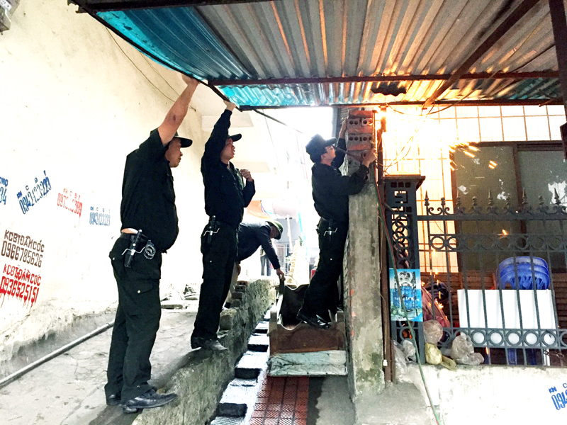 Lực lượng chức năng phường Hồng Hà, TP Hạ Long tháo dỡ mái che của hộ dân lấn chiếm vỉa hè làm nơi kinh doanh.