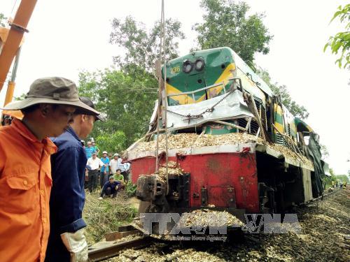 Lực lượng cứu hộ đang khắc phục sự cố đầu máy bị trật khỏi đường ray để thông tuyến đường sắt Bắc - Nam. Ảnh: Nguyên Linh/TTXVN