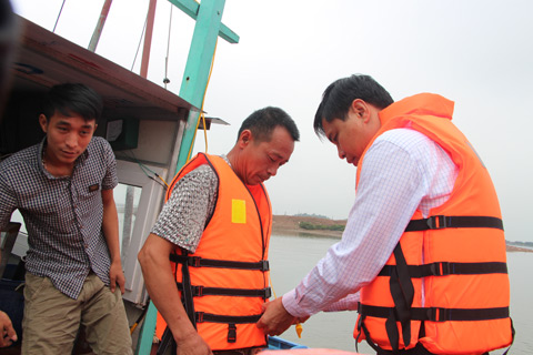 Đồng chí Vũ Văn Diện, Phó Chủ tịch UBND tỉnh, Phó Trưởng Ban phụ trách Ban ATGT tỉnh hướng dẫn mặc áo phao cho ngư dân 