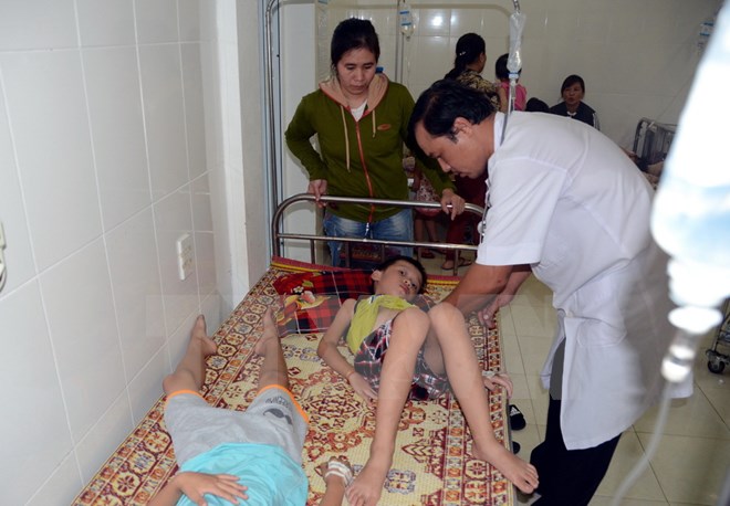 Các y, bác sỹ Trạm y tế phường Nghi Hòa, Thị xã Cửa lò (Nghệ An) đang cấp cứu, điều trị cho các em học sinh bị ngộ độc. (Ảnh: Tá Chuyên/TTXVN)