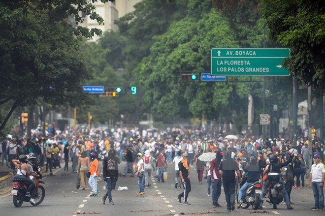 Người biểu tình bạo loạn xung đột với cảnh sát tại thủ đô Caracas, Venezuela, ngày 20/4. (Nguồn: AFP/TTXVN)