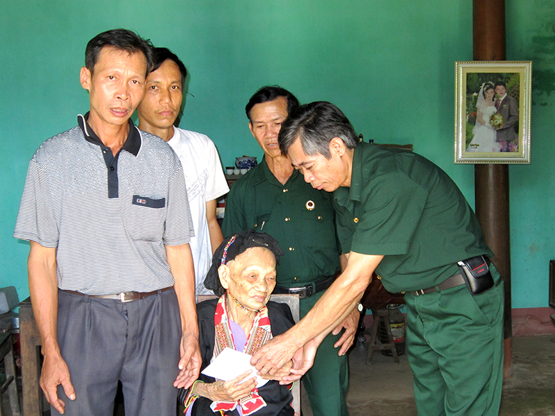 CCB Trần Quốc Mạnh (ngoài cùng, bên phải) tặng sổ tiết kiệm của Hội CCB huyện Hoành Bồ cho mẹ liệt sĩ ở thôn Phủ Liễn, xã Đồng Sơn, huyện Hoành Bồ. (Ảnh do nhân vật cung cấp)
