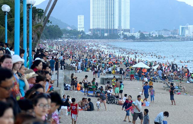 Ngày 30/4, trong cái nắng oi bức, hàng nghìn người từ nhiều nơi đổ về bãi biển Nha Trang nghỉ lễ khiến nơi đây đông nghẹt. (Ảnh: VnExpress)