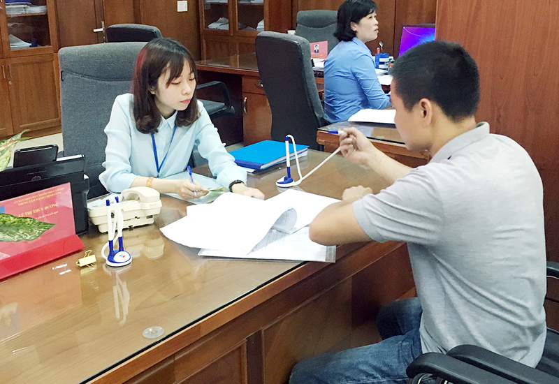 Công chức Trung tâm Hành chính công TP Cẩm Phả hướng dẫn doanh nghiệp thực hiện thủ tục hành chính.