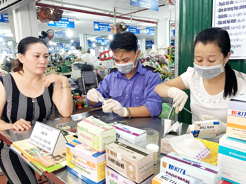 Nhân viên Ban Quản lý chợ Cái Dăm, phường Bãi Cháy, TP Hạ Long tiến hành test nhanh thực phẩm.