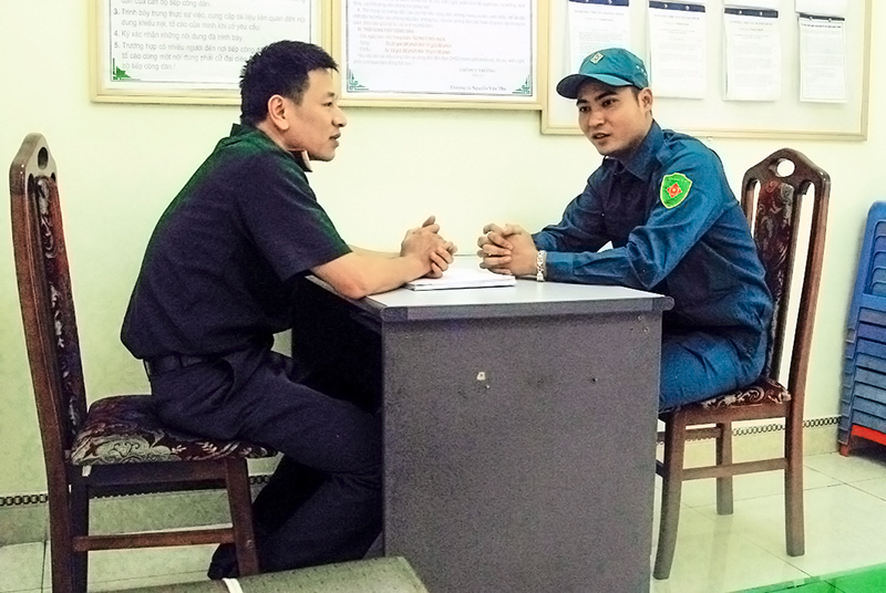 Anh Lê Đức Hoà, chiến sĩ Trung đội tự vệ biển Công ty CP Vật tư - TKV (bên phải) báo cáo, trao đổi tình hình hoạt động của đội với cán bộ Ban CHQS TP Cẩm Phả.