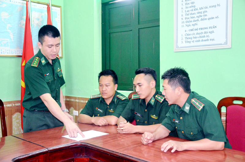 Thượng uý Trần Xuân Thành (người đứng) trao đổi công việc với cán bộ, chiến sĩ trong đơn vị. 