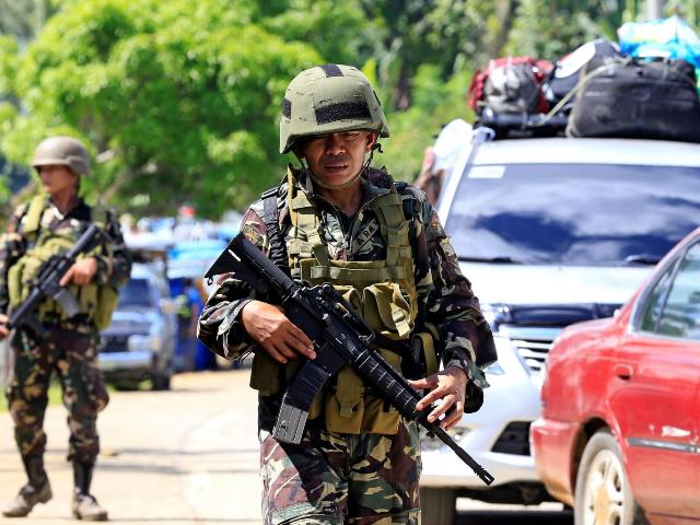 Lực lượng chính phủ đứng tại một trạm kiểm soát trên đường cao tốc tại thị trấn Pantar sau khi dân sơ tán khỏi thành phố Marawi.