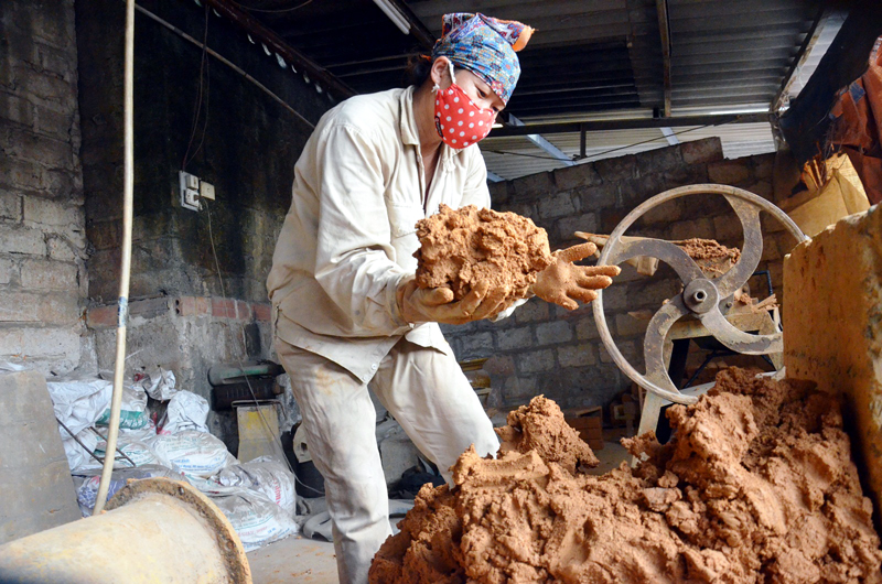 Người thợ làm gốm lựa chọn đất sét nguyên liệu để chế tác sản phẩm.