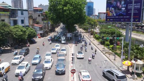 Người lưu thông trên đường trú vào bóng râm tránh nắng nóng khi chờ đèn đỏ tại cầu vượt ngã tư phố Nguyễn Chí Thanh – đường Láng. Ảnh: Hoàng Hùng - TTXVN