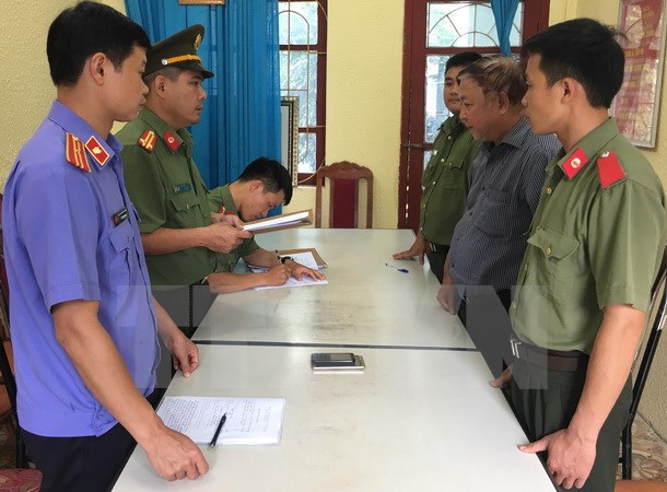 Đối tượng Nguyễn Hồng Bài (áo kẻ) tại cơ quan Công an. (Ảnh: Nguyễn Cường/TTXVN)