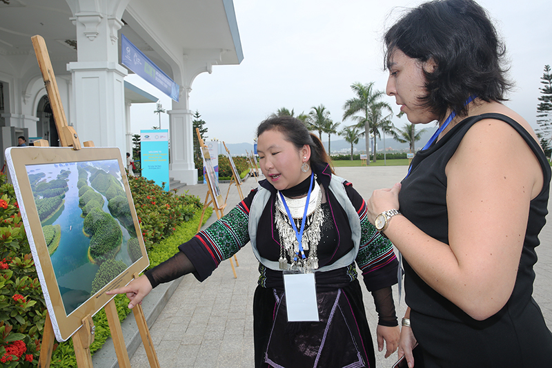 Đại biểu quốc tế xem một số hình ảnh cảnh quan du lịch của Việt Nam được trưng bày tại hội nghị
