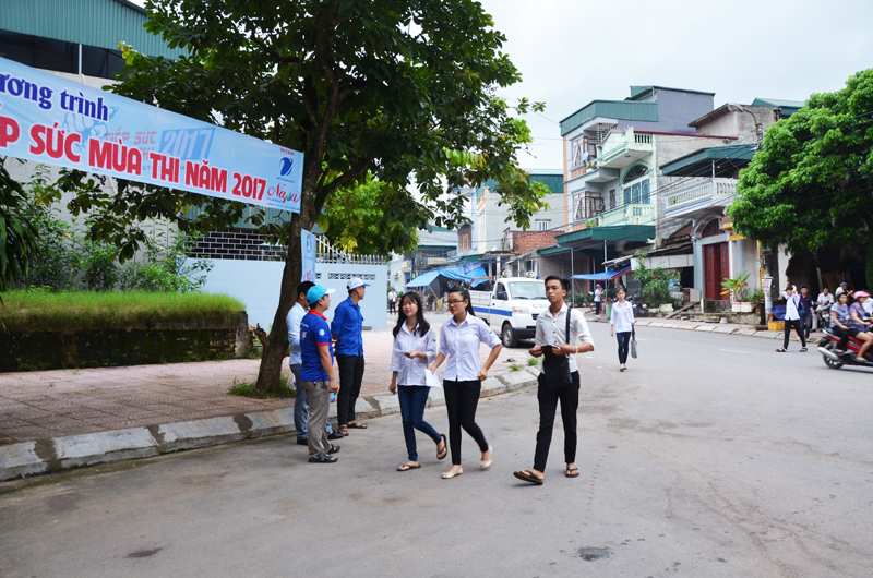 Lực lượng đoàn viên thanh niên đứng trước cổng điểm thi để hỗ trợ thí sinh