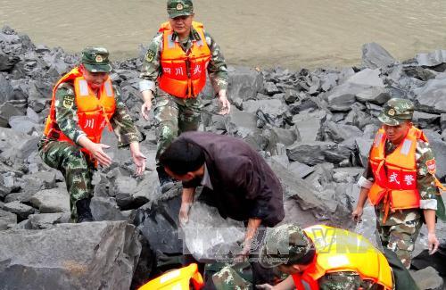 Lực lượng cứu hộ làm nhiệm vụ tại hiện trường vụ lở đất. AFP/TTXVN