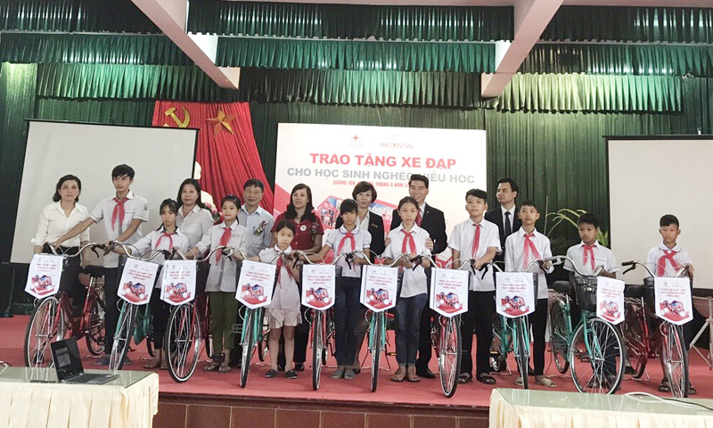 Đại diện Công ty BHNT Prudential Việt Nam và Hội CTĐ Quảng Ninh trao xe đạp cho các học sinh.