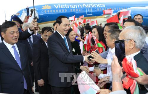 Cán bộ, nhân viên Đại sứ quán Việt Nam và đại diện cộng đồng người Việt Nam tại Cộng hoà Belarus đón Chủ tịch nước Trần Đại Quang và Phu nhân tại sân bay Quốc tế Minsk. Ảnh: Nhan Sáng/TTXVN