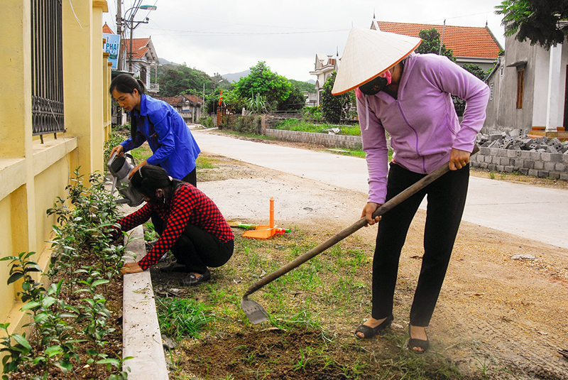 Hội viên phụ nữ xã Cẩm Hải ra quân dọn vệ sinh, chăm sóc hoa, cây xanh dọc tuyến đường thôn 4 - thôn điểm thực hiện xây dựng thôn kiểu mẫu của xã.