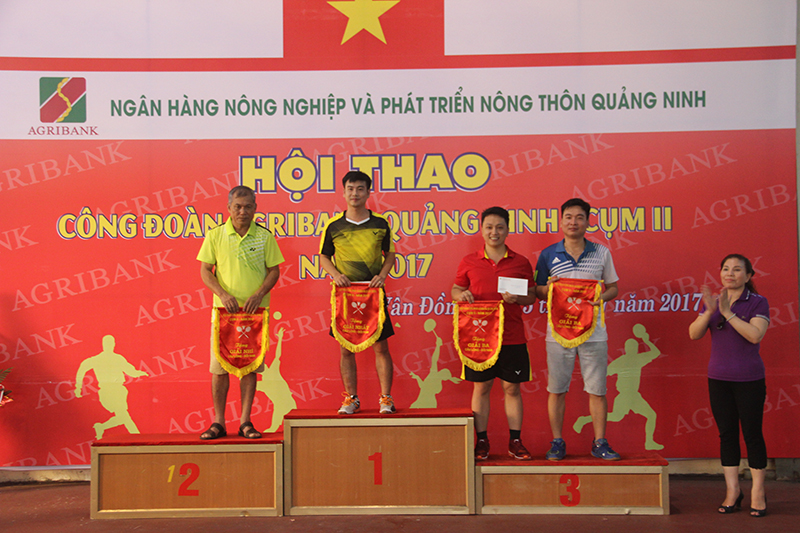 Ban tổ chức trao giải nhất đôi nam bộ môn cầu lông cho vận động viên của Agribank huyện Tiên Yên
