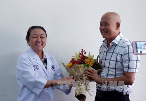 Bác sĩ khoa Huyết học tặng hoa chúc mừng bệnh nhân Dương Văn Quang. Ảnh: Phương Vy-TTXVN