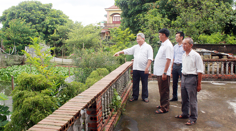Cán bộ thôn Bình Sơn Đông (xã Bình Dân, TX Đông Triều) hướng dẫn gia đình ông Lâm Văn Hiền (ngoài cùng, bên trái) xây dựng vườn mẫu.