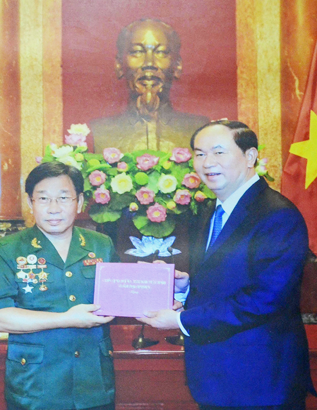Ông Trần Hoàng Mai nhận quà của Chủ tịch nước Trần Đại Quang tại cuộc gặp mặt của Chủ tịch nước với Đoàn đại biểu cựu quân nhân tình nguyện Việt Nam giúp Campuchia, tổ chức tại Hà Nội ngày 17-6-2017.                                       (Ảnh do nhân vật cung cấp)