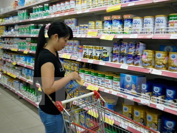 Khách hàng chọn mua sữa bình ổn giá tại Siêu thị Co.op Mart Thanh Hà. (Ảnh: Lan Phương/TTXVN)
