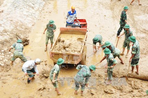 Các chiến sĩ tham gia dọn dẹp bùn đất tại trường học ở huyện Mù Cang Chải (Yên Bái). Ảnh: Đinh Hữu Dư/TTXVN