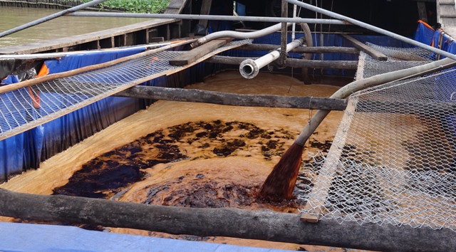 Nước thải từ Công ty Huy Việt – Tây Đô đang bơm xuống ghe để mang đi xả thải. (Ảnh:DT)
