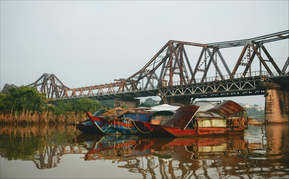 Sông Hồng mùa nước nổi một sớm tinh sương với những con thuyền im lìm dưới chân cây cầu lịch sử trăm tuổi đem lại cảm giác bình yên, một nỗi nhớ những gì xưa cũ. Ảnh: Kim Thanh Tran.