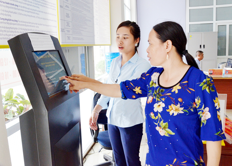 Cán bộ Trung tâm HCC TX Đông Triều hướng dẫn người dân giải tra cứu TTHC tại kios điện tử.