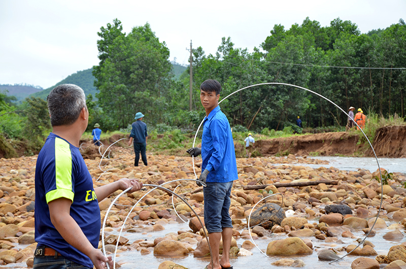 Người dân hỗ trợ cùng công nhân ngành điện kéo dây điện tại đội 2, thôn Phủ Liễn, xã Đồng Sơn, huyện Hoành Bồ.