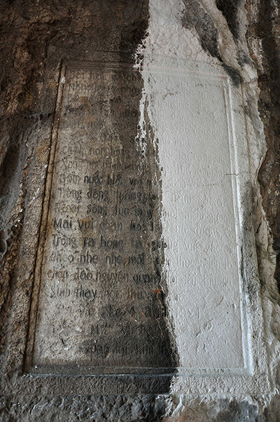 Cận cảnh bài thơ của bà Đào Thị Kim Thoa (phần trắng là do nước mưa làm đá vôi phong hoá chảy xuống).