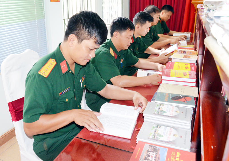 Cán bộ, chiến sĩ Ban CHQS TX Đông Triều tìm đọc nhiều loại sách, báo tại phòng truyền thống của đơn vị.