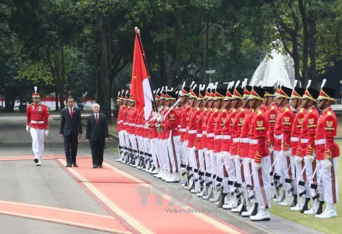 Tổng thống Indonesia Joko Widodo và Tổng Bí thư Nguyễn Phú Trọng duyệt đội danh dự tại lễ đón. Ảnh: Trí Dũng/TTXVN