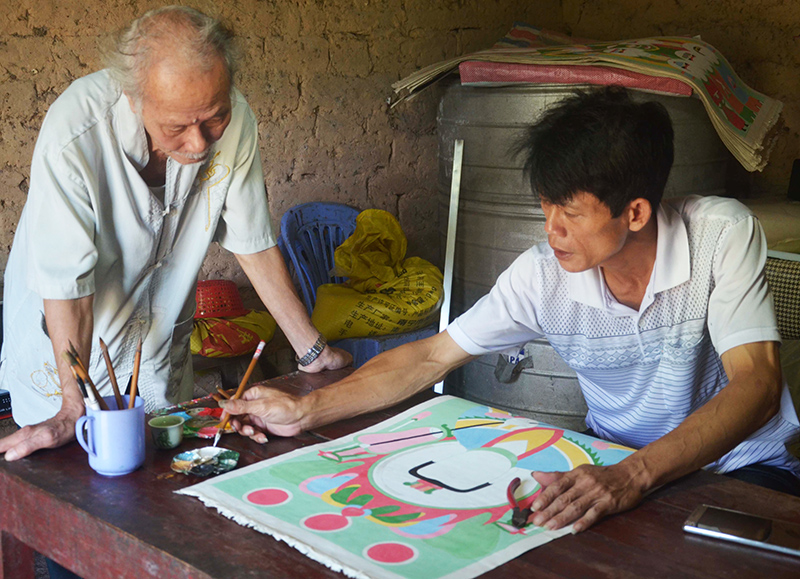 Nghệ nhân Hoàng Văn Tài, người Dao Thanh Phán ở xã Đông Hải (Tiên Yên) đang hoàn thiện một bộ tranh thờ. 