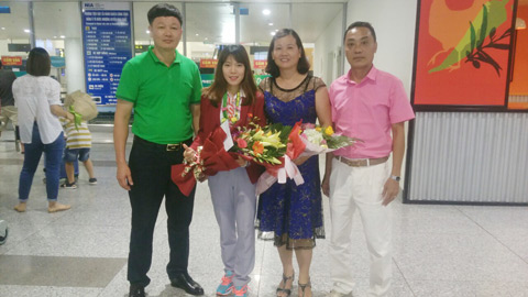 Lãnh đạo Trung tâm TDTT tặng hoa chúc mừng VĐV Phạm Thị Huệ tại sân bay Nội Bài. Ảnh: CTV 