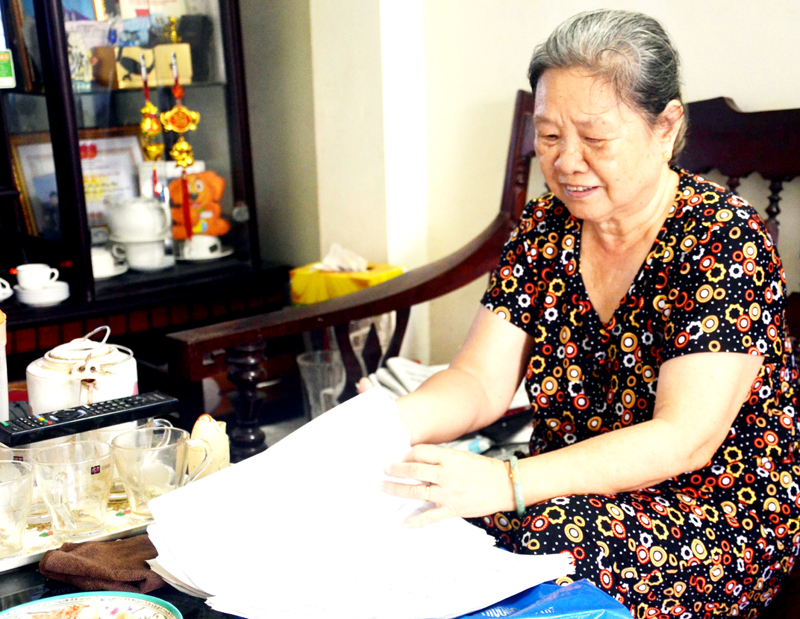Bà Nguyễn Thị Hồng Thái xem lại tư liệu về người cha của mình.