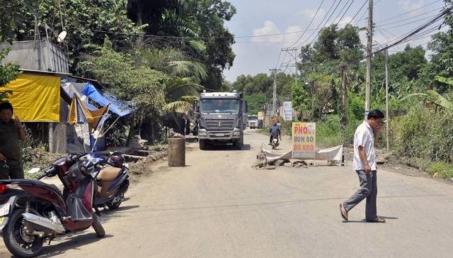 Người dân dùng vật cản ngăn xe chở đá trên đường Đinh Quang Ân (TP Biên Hòa, tỉnh Đồng Nai).
