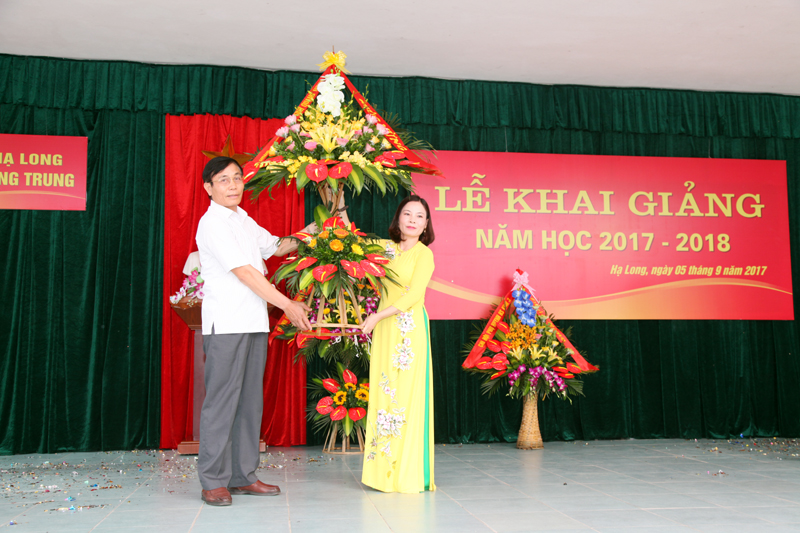 Đồng chí Vũ Ngọc Giao, Ủy viên Ban Thường vụ Tỉnh ủy, Trưởng Ban Tổ chức Tỉnh ủy tặng hoa chúc mừng thầy và trò trường Tiểu học Quang Trung.