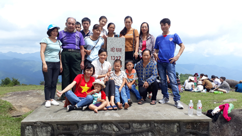 Du khách chụp ảnh lưu niệm tại cột mốc Biên giới Bình Liêu (Ảnh: LA LÀNH)