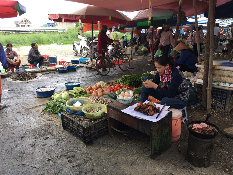 Thức ăn chín được bày bán ngay cạnh hàng thực phẩm sống, không được che chắn tại chợ Trới (huyện Hoành Bồ) 
