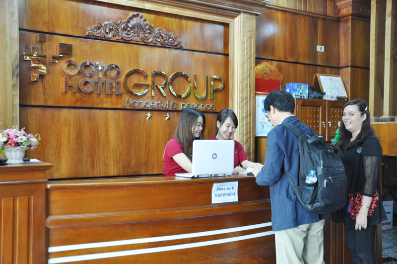 Dịch vụ lưu trú ngày càng được nâng cao chất lượng (Nhân viên lễ tân khách sạn Cô Tô Group đang trao đổi với khách hàng)