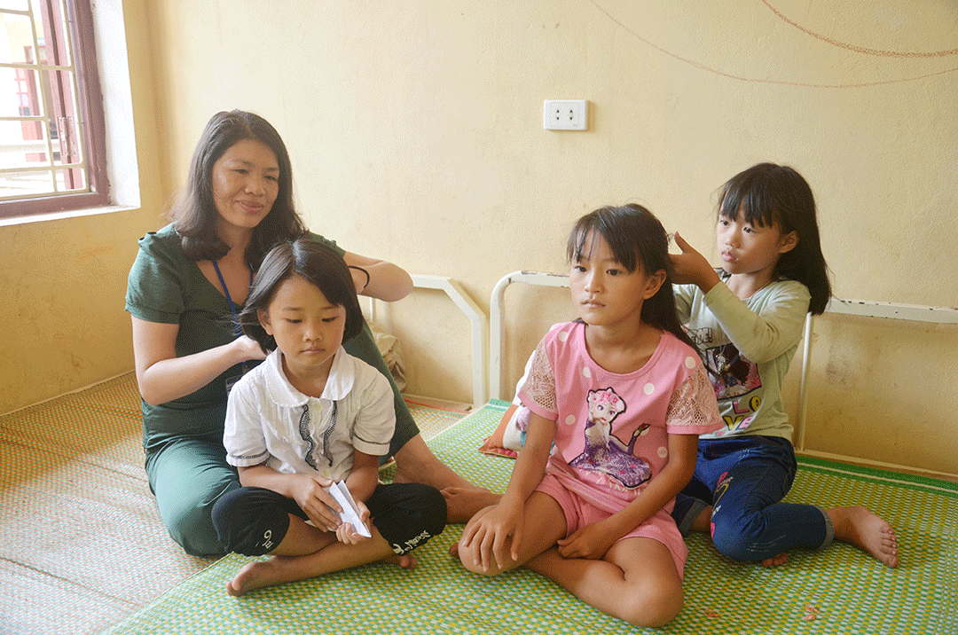 Cô giáo Đào Thị Hà, giáo viên dạy tiểu học Trường TH&THCS Đồng Sơn chăm sóc cá nhân cho em Đặng Thanh Phong, học sinh lớp 1, chuyển từ điểm Khe Kẻn ra điểm trung tâm từ năm học 2017-2018