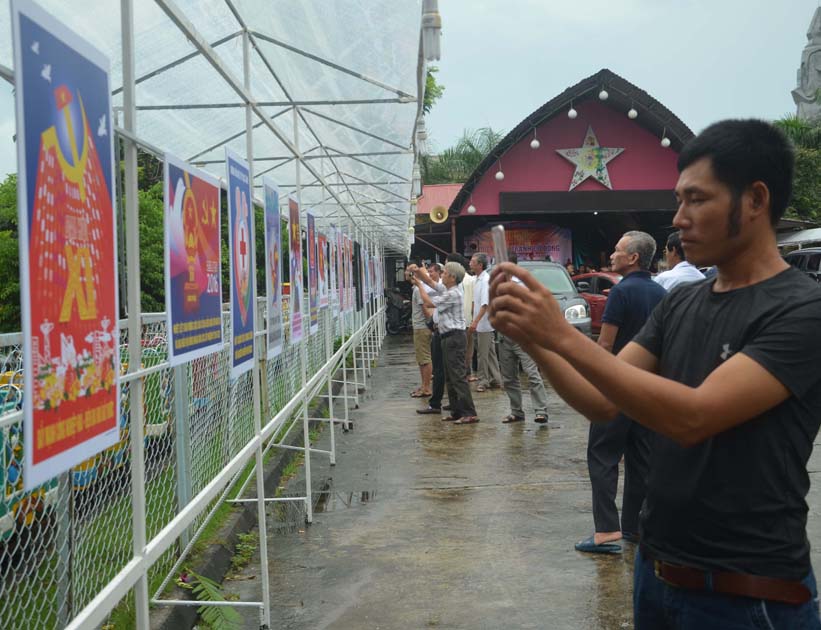 Đại biểu thăm quan triển lãm tranh cổ động của hoạ sĩ Nông Quốc Hiệp mở cửa tại TP Uông Bí. 