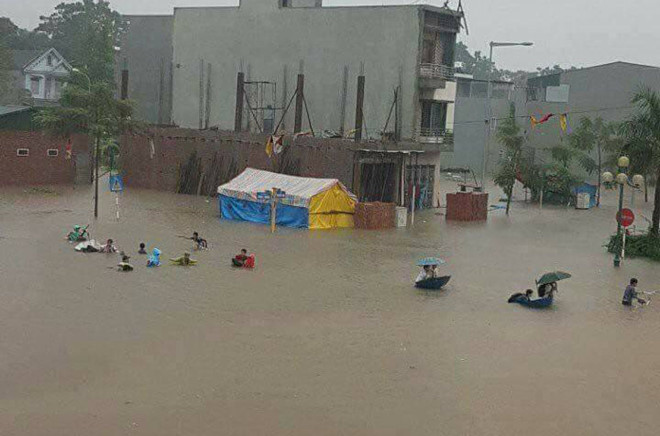 Người dân lội qua nước ngập sâu tại TP Việt Trì. Ảnh: Nguyễn Linh.