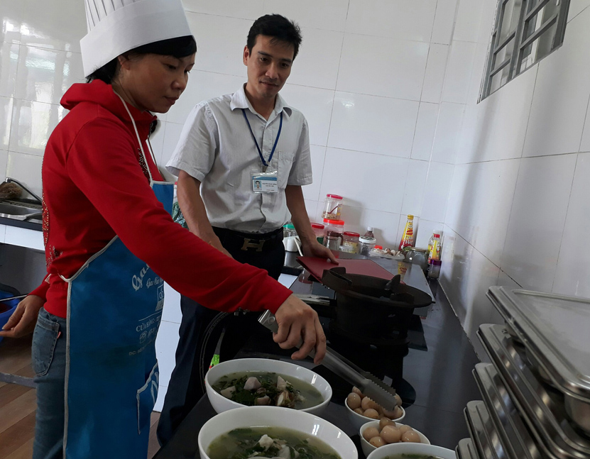 Cán bộ Chi Cục An toàn vệ sinh thực phẩm Quảng Ninh hướng dẫn một hộ kinh doanh quy trình chế biến và bảo quản thực phẩm. 