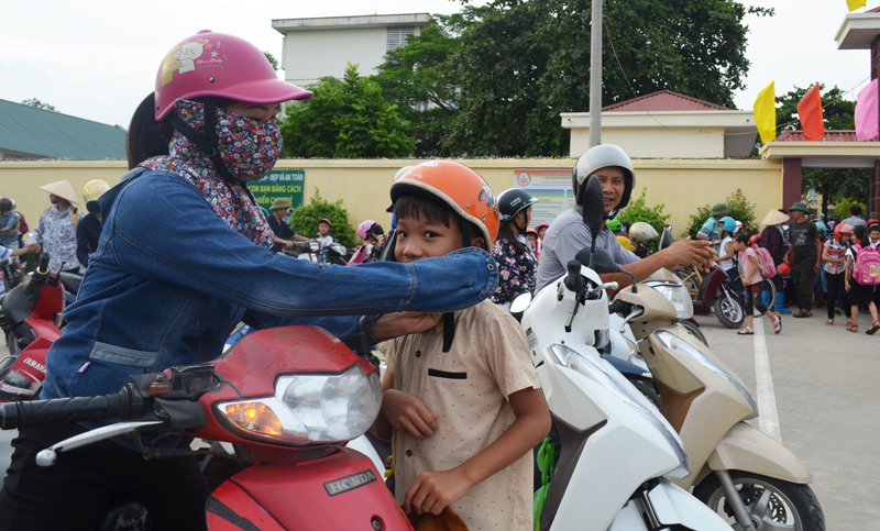 học sinh của trường có ý thức đội mũ bảo hiểm trước khi lên xe máy