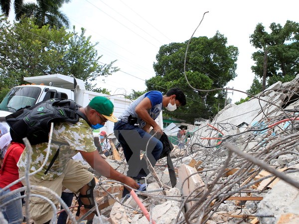 Tình nguyện viên dọn dẹp hiện trường đổ nát sau vụ động đất tại Mexico City. (Nguồn: THX/TTXVN)