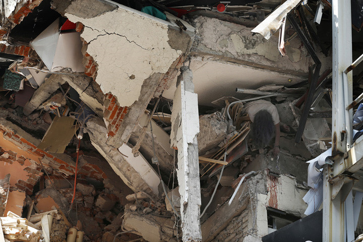 Một phụ nữ bị chèn tử vong bên trong tòa nhà sập một phần do trận động đất kinh hoàng trên diện rộng ở Mexico. Ảnh: AP.